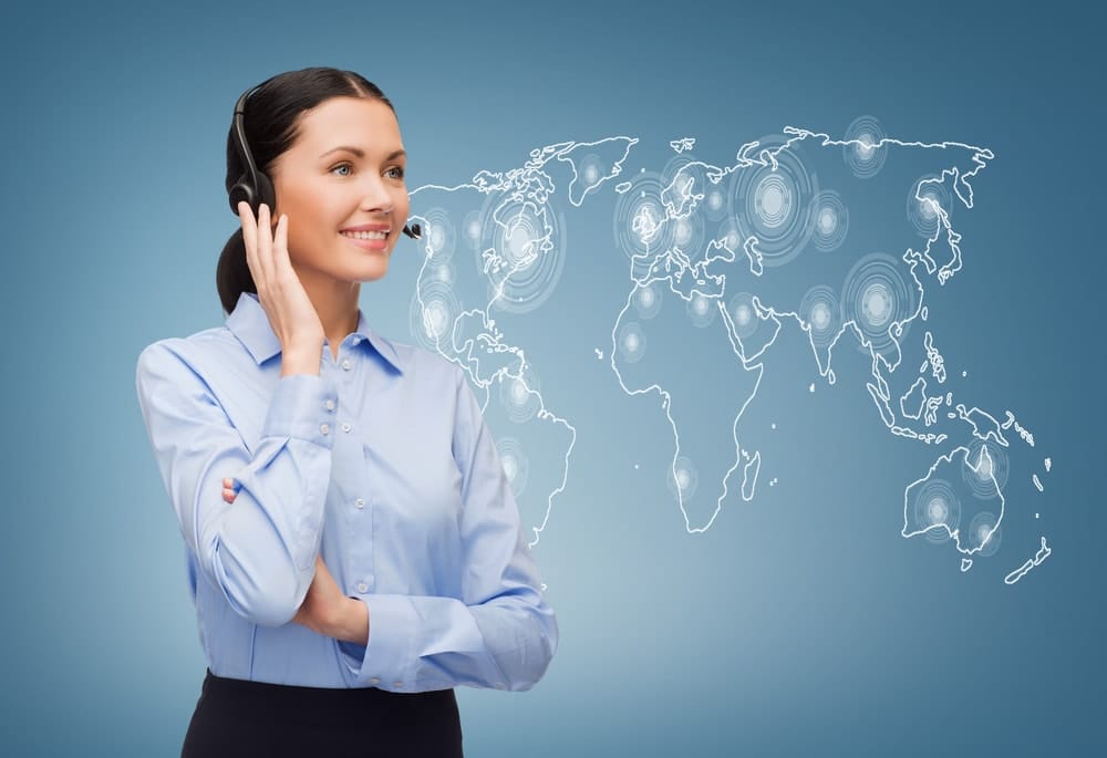 woman standing and listening on headset next to world map