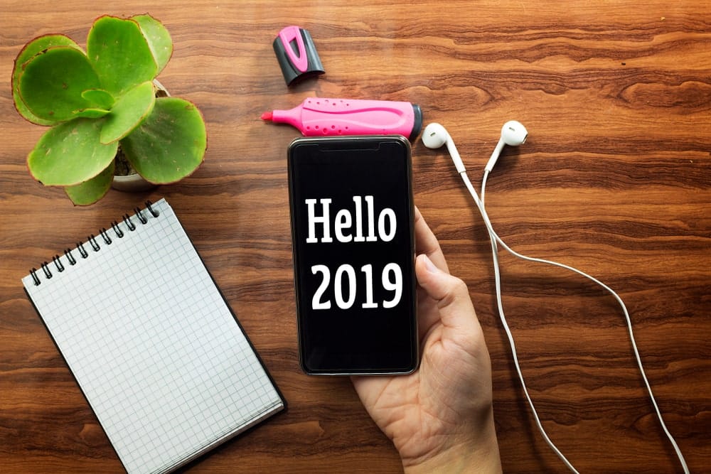 Phone with Hello 2019 on it in front of wood table