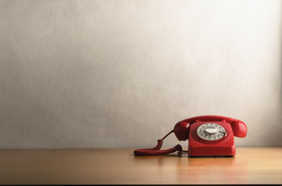 Red rotary phone on wood table